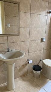 a bathroom with a sink and a toilet at Simar Hotel in Araranguá