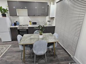 a kitchen with a table and chairs and a kitchen with at Private One Bedroom Flat in Barnet, London in Finchley