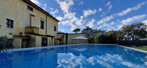 une piscine devant un immeuble avec un ciel dans l'établissement Casale Paola - Belcanto Villas, à Pietrasanta