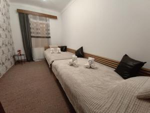 trzy wypchane zwierzęta siedzące na dwóch łóżkach w pokoju w obiekcie Casa Iulia w Braszowie