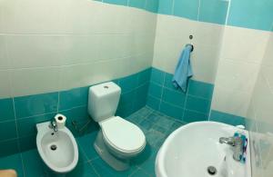 a blue and white bathroom with a toilet and a sink at Big apartment city center in Shkodër +3 photos