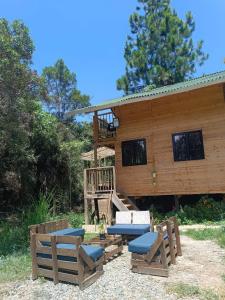 une cabane en rondins avec une véranda et une terrasse dans l'établissement Cabaña con Jacuzzi privado/BBQ y Chimenea ecológica, à Guarne
