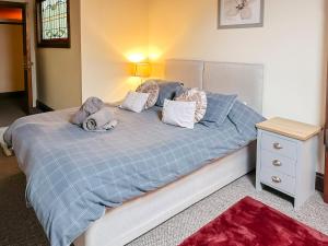 a bedroom with a bed with a blue comforter and pillows at 4-bed penthouse - Old Converted Church - FREE Parking in Pontypool