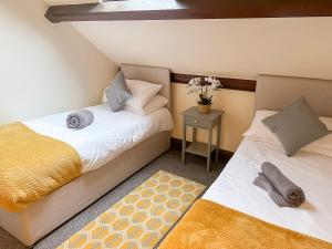 two beds sitting next to each other in a room at 4-bed penthouse - Old Converted Church - FREE Parking in Pontypool