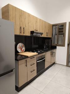 a kitchen with wooden cabinets and a stove top oven at AEROPORT TECHNOPOLIS a1 in Oulad Yakoub