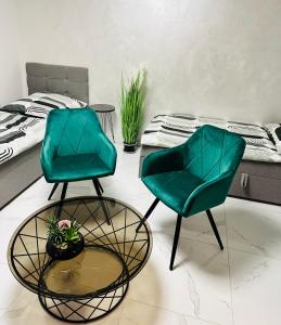 two chairs and a table in a room with a bed at FeWo BEE61 * Langen EXKLUSIV für 4 Personen *Vollausstattung mit Küche* inklusive TERRASSE in Langen