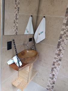 a bathroom with a wooden bowl sink and towels at Glamping Caelum. Refugio al aire libre, en Macheta Cundinamarca in Machetá