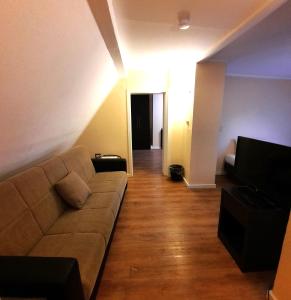 ein Wohnzimmer mit einem Sofa und einem TV in der Unterkunft Hotel Ariana in Köln