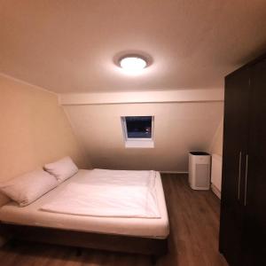 um pequeno quarto com uma cama com uma luz sobre ela em Hotel Ariana em Colónia