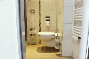 uma casa de banho com um WC branco num quarto em Skyline Hotel Hannover em Hanôver
