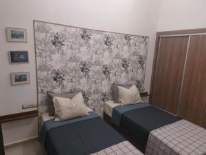a room with two beds and a wall at AEROPORT TECHNOPOLIS a1 in Oulad Yakoub