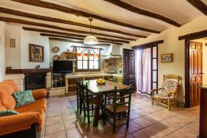 Il comprend une cuisine et un salon avec une table et des chaises. dans l'établissement Casa Suryta einzigartiges Landhaus bei Granada, à Dúrcal