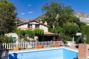 una casa con una valla blanca y una piscina en Casa Suryta einzigartiges Landhaus bei Granada en Dúrcal