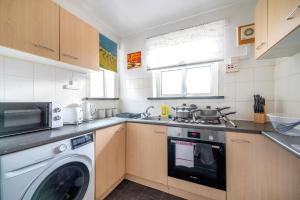a kitchen with a washer and a washing machine at *RA26S* For your most relaxed & Cosy stay + Free Parking + Free Fast WiFi * in Adel