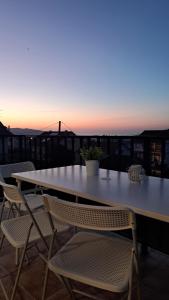 une table et des chaises sur un toit avec un coucher de soleil dans l'établissement Casa da Morriña, à Cabana de Bergantiños