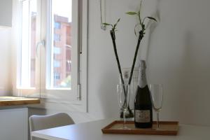 Una botella de vino y dos copas en una mesa. en Bambú Suites Vegueta, en Las Palmas de Gran Canaria