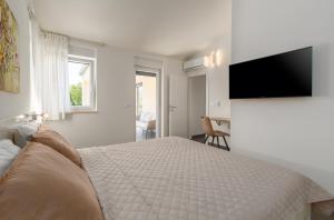 a bedroom with a bed and a flat screen tv at Villa Opal in Tar