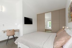 a white bedroom with a bed and a television at Villa Opal in Tar +11 photos