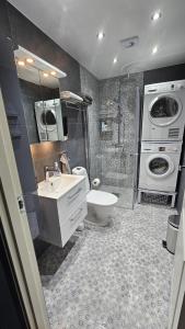 a bathroom with a sink and a washing machine at Attic floor with views over fields and sea in Sigtuna