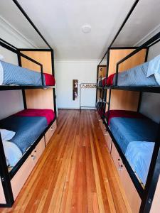 two bunk beds in a room with a wooden floor at Enjoy Hostel in Santiago