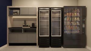 a kitchen with a refrigerator with drinks in it at Hotel Coroados Foz Express in Foz do Iguaçu