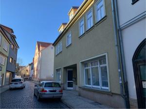 twee auto's geparkeerd in een straat naast een gebouw bij Bella Vita in Gotha