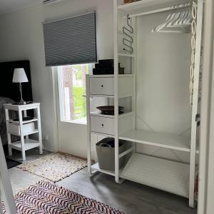 a white book shelf in a room with a bed at Vuolenkosken Helmi - laadukas ympärivuotinen kohde in Huutotöyry