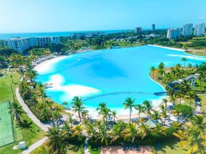 una vista aérea de una gran piscina con palmeras y una playa en ABBY TOURISM, en Playa Blanca