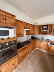 a kitchen with wooden cabinets and a microwave at Király Családi Apartman- Royal Family Apartment in Budapest