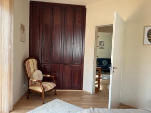 a bedroom with a wooden door and a chair at Király Családi Apartman- Royal Family Apartment in Budapest