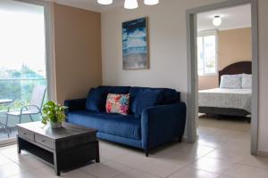 sala de estar con sofá azul y cama en Great family apartment in Tegucigalpa en Tegucigalpa