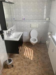 bagno con servizi igienici bianchi e lavandino di Wohlfuehl Wohnung mit Sternekomfort in Tanne a Tanne