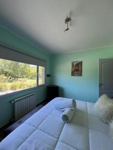 a bedroom with a large bed with a large window at Tandil del Lago in Tandil