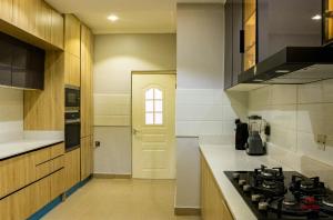 a kitchen with a stove top oven in a room at 99 MOZILLA APARTMENTS AND SUITES in Abuja