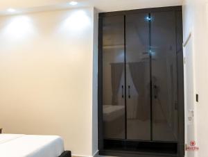 un bagno con doccia e un letto di 99 MOZILLA APARTMENTS AND SUITES ad Abuja