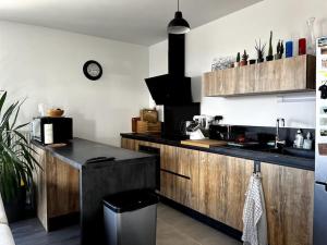 cocina con armarios de madera y encimera en Appartement lumineux Colombes JO 2024, en Colombes