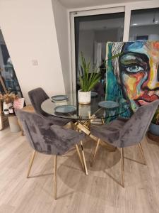 een tafel en stoelen in een kamer met een schilderij bij Beckenham- Stunning Double Bedroom With En-suite in SHARED APARTMENT in Elmers End