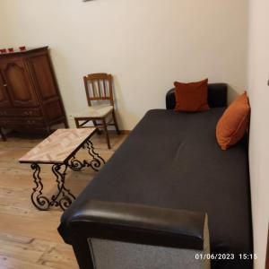 Room in BB - Chambre Z2 A Bruxelles في بروكسل: غرفة نوم مع أريكة سوداء وكرسي