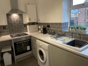 a kitchen with a washing machine and a sink at Saltwell Rd - 4 Bdrm 5 beds Great for contractors in Gateshead