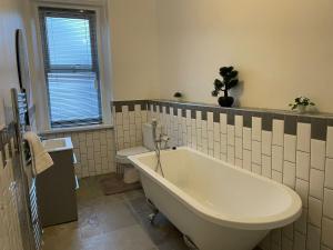 a bathroom with a bath tub and a toilet at Saltwell Rd - 4 Bdrm 5 beds Great for contractors in Gateshead
