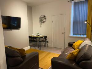 a living room with a couch and a table at Saltwell Rd - 4 Bdrm 5 beds Great for contractors in Gateshead