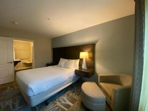 a hotel room with a bed and a chair at Staybridge Suites Syracuse Liverpool by IHG in Liverpool +61 photos