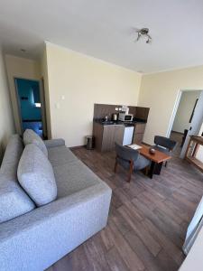 ein Wohnzimmer mit einem Sofa und einem Tisch in der Unterkunft Tandil del Lago in Tandil