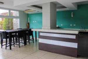 uma cozinha com um balcão, uma mesa e cadeiras em Great family apartment in Tegucigalpa em Tegucigalpa