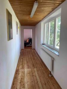 pasillo vacío con techo de madera y ventana en Entire apartment in Eggenfelden, en Eggenfelden