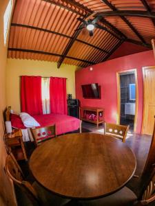 Zimmer mit einem Holztisch, einem Bett und einem Schlafzimmer in der Unterkunft Casa Morada in Antón