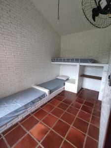 um quarto com 2 camas e piso em azulejo vermelho em Holambra e a natureza rural em Holambra