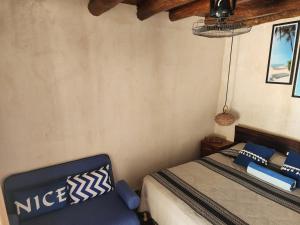 1 dormitorio con 1 cama y 1 silla azul en Playa las palmas, en Tulum