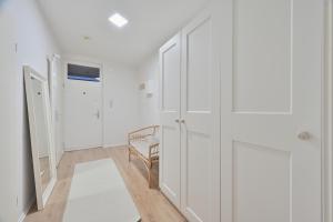 a white room with white cabinets and a chair at Goodliving Apartments Studio mit Balkon & Netflix in Essen