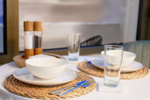 a table with plates and bowls and a glass of water at Goodliving Apartments Studio mit Balkon & Netflix in Essen